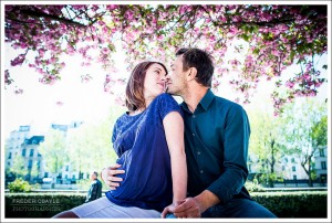 Couple en extérieur durant la grossesse avec les arbres en fleurs