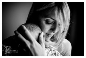 Portrait en noir et blanc d'une maman serrant son bébé contre elle