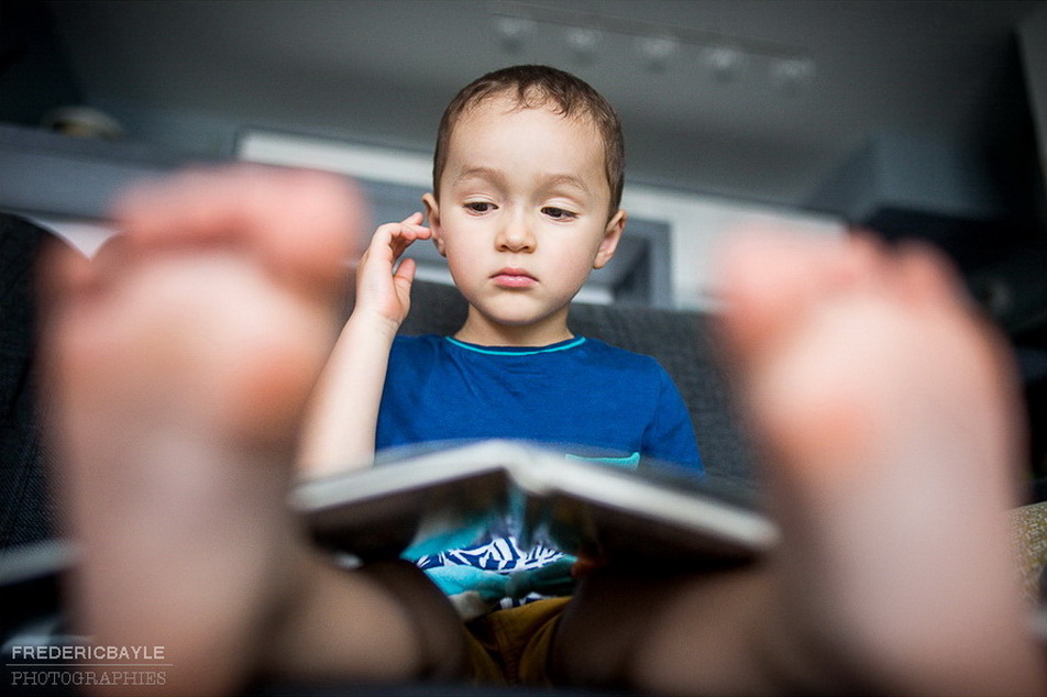 petit garçon lisant un livre sur un reportage famille