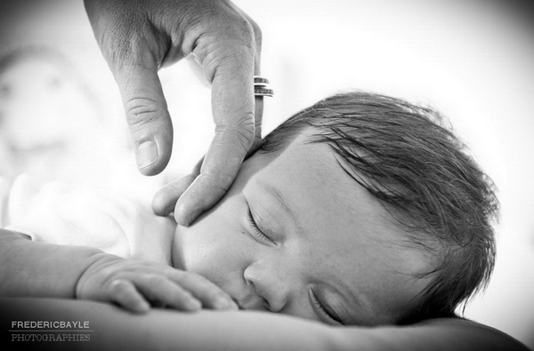 bébé qui dort caressé par la main de sa maman