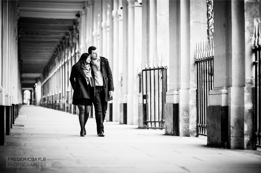 couple enlacé déambulant dans les arcades du Palais Royal à Paris