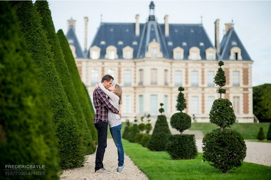 jeune couple s'enlaçant devant le Château de Sceaux