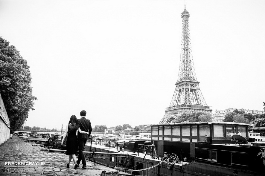 deux jeunes asiatiques enlacés marchant avec la Tour Eiffel en arrière plan