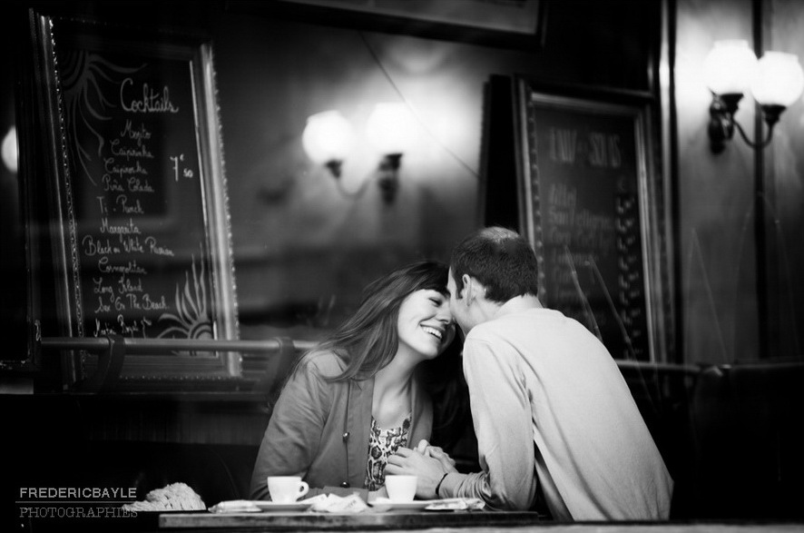 baiser d'amoureux dans un café parisien